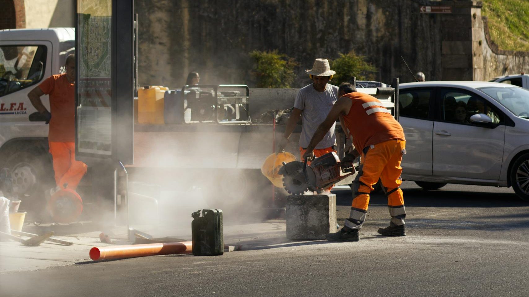 Road construction workers busy in Lucca, Tuscany, Italy during daytime.